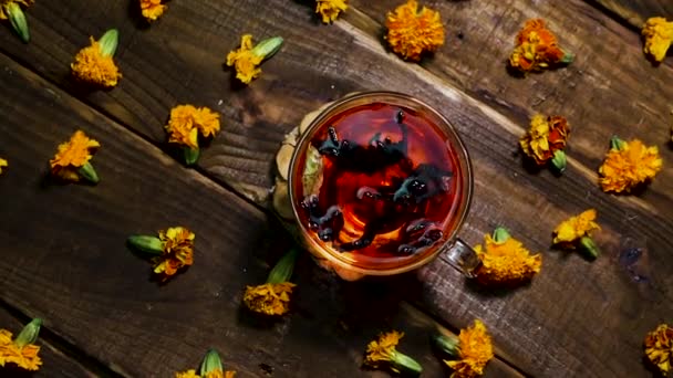 抗氧化红茶放在木制桌子上 天然的由金银花制成 顶部观景 茶可以御寒 自然疗法药用饮料 用慢镜头拍摄 — 图库视频影像