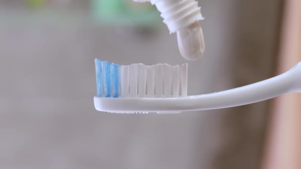 牙膏被用在牙刷上 在浴室的Bokeh背景上的特写 牙齿清洁概念 — 图库视频影像