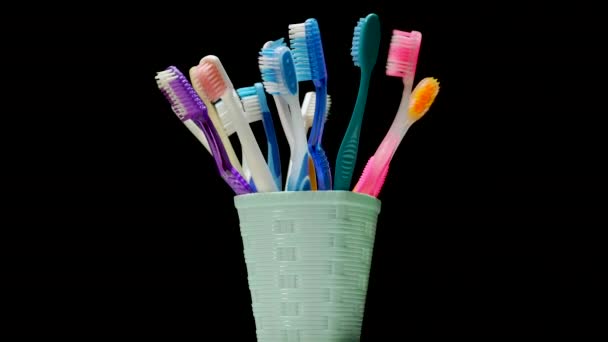 篮子里的许多牙刷在黑色的背景上旋转着 照顾牙齿 五彩斑斓的牙刷 — 图库视频影像