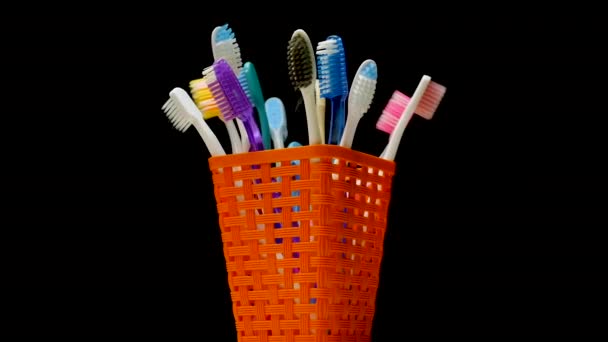 Πολλές Οδοντόβουρτσες Πορτοκαλί Καλάθι Περιστρέφονται Μαύρο Φόντο Φροντίδα Για Δόντια — Αρχείο Βίντεο