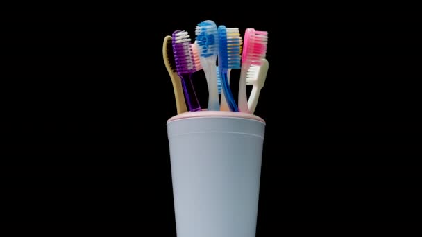 Πολλές Οδοντόβουρτσες Ένα Ποτήρι Περιστρέφονται Μαύρο Φόντο Φροντίδα Για Δόντια — Αρχείο Βίντεο