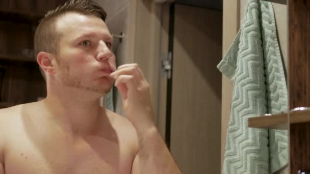Красивий Молодий Чоловік Чистить Зуби Ванній Допомогою Медичної Зубної Пасти — стокове відео