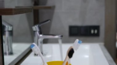 Eline bir diş fırçası al. Banyoda bir çantada diş fırçası seti. Diş bakımı