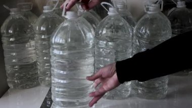 Ukrayna 'daki savaş sırasında dairede şişe su vardı. Bir kişi bir dairede içmek ya da yemek pişirmek için yağmur suyu depoluyor ya da depoluyor. Savaş sırasında içilen suyla dolu bir sürü plastik şişe.