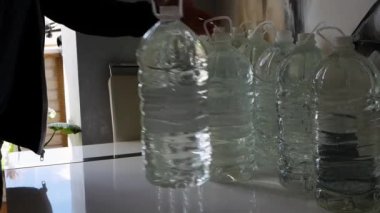 Ukrayna 'daki savaş sırasında su kaynakları. Bir kişi bir dairede içmek ya da yemek pişirmek için yağmur suyu depoluyor ya da depoluyor. Savaş sırasında içilen suyla dolu bir sürü plastik şişe.