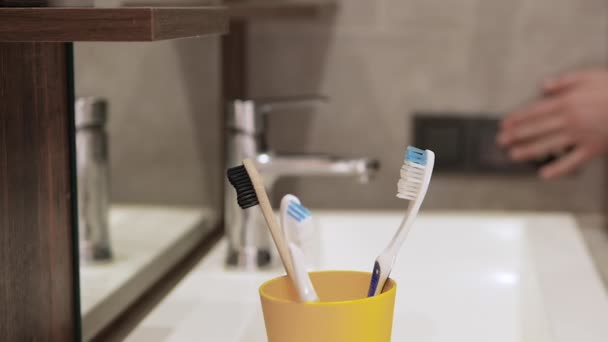 打开浴室的灯 在浴室里的一个箱子里刷牙 浴室里的人手里拿着牙刷 卫生和牙科保健 — 图库视频影像