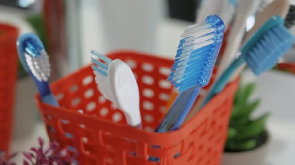特写男子的手从浴室的箱子里捡起牙刷 口腔卫生 在浴室刷牙 牙科保健 牙刷在篮子里 — 图库视频影像