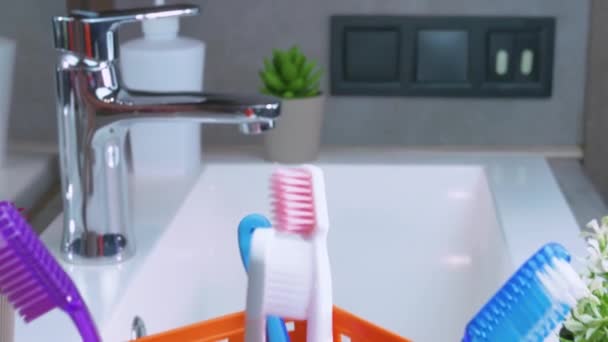 Muitas Escovas Dentes Uma Cesta Laranja Plataforma Giratória Banheiro Cuidados — Vídeo de Stock