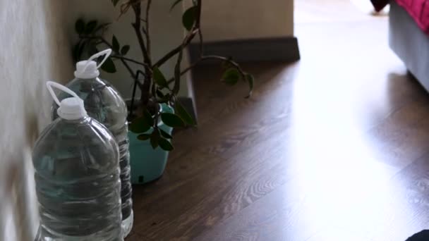 一个男人在他的公寓里储存瓶装水 一个乌克兰男人在战争期间国家缺水的情况下储存水 一个人把水瓶装进了储藏室 供水紧急 — 图库视频影像