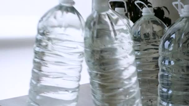 男は飲料水の供給を格納します ボランティアはウクライナでの戦争中に人々に水を供給します 6リットルのボトルに飲料水を保管してください ボトル入りの水を飲むのクローズアップ ウクライナ人のための飲料水の準備 — ストック動画