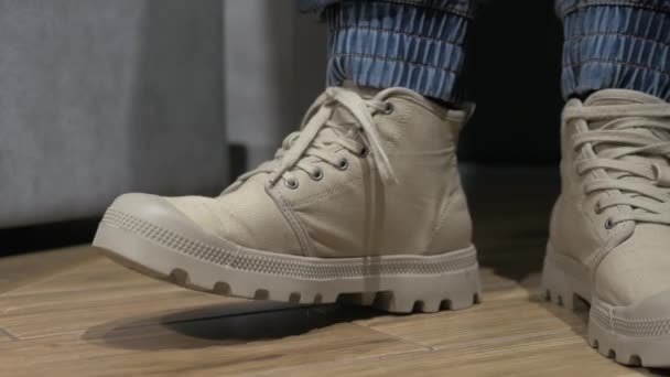 地面に足を踏みなさい タイルに足をぶつけたブーツの男の足 感情ボディランゲージ メンズブーツ — ストック動画