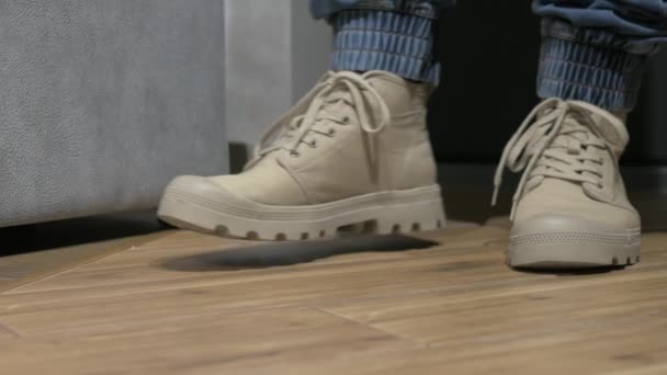 クローズアップ若い男は彼の足の上に近代的な靴を置き 灰色の男性の靴をレースアップ 男の手の靴をレースアップ 帰ってくる足 メンズブーツ — ストック動画