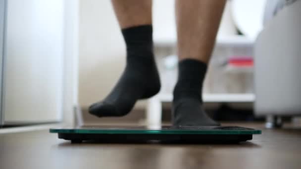 没有脂肪的健康身体的概念 一个人站在地板上测量体重 一个人的腿站在天平上 — 图库视频影像