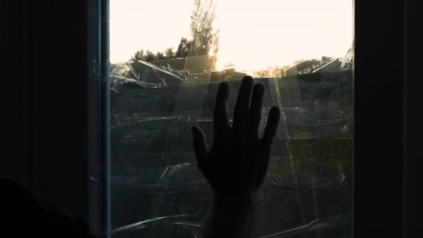 男の手は窓のガラスの上を滑り 窓はロケット爆発のスコッチテープで覆われている ウクライナの軍事不況の男 窓は爆風テープで密封されている 老人が手で窓に触れると — ストック動画