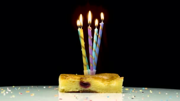 燃えるろうそくと多色の燃焼ろうそく幸せな誕生日の背景 ろうそくが回転して記念日ケーキを食欲をそそる アップルパイはお祝いのテーブルの上で回転 — ストック動画
