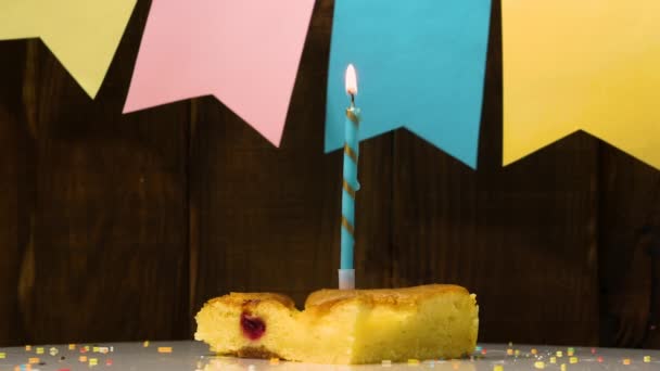 木の板の背景に燃えるろうそくと幸せな誕生日の背景を燃やす ろうそくが回転して記念日ケーキを食欲をそそる アップルパイはお祝いのテーブルの上で回転 — ストック動画
