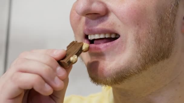 Jeune Homme Souriant Mange Chocolat Avec Une Noix Beau Sourire — Video
