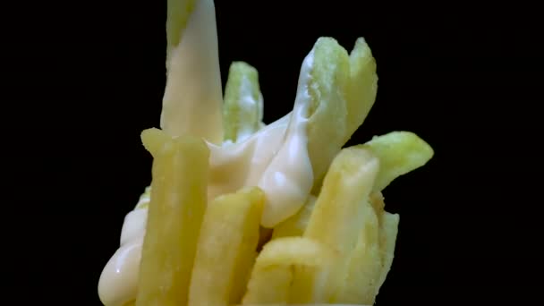 在黑色背景上涂蛋黄酱的特写薯条旋转着 开胃土豆和苏一起吃 转盘上的油炸土豆 — 图库视频影像