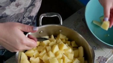 Kadın eli bıçakla tencerede yemek pişirmek için patates keser. Kamp alanında yemek pişirmek. Kabuksuz patates kes.