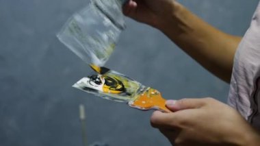 Duvarı boyamak için sulu boyaları karıştırıyorum. Bir spatula üzerinde akrilik boya. Modern bir iç mekan için sarı renkli siyah boya. Renk yaratan kız.