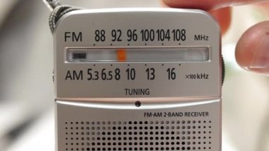 Bir adam radyoda radyo dalgası ayarlıyor. Anteni olan antika alıcı. Bir ölçekte analog radyo ayarla. Bir adam eski bir radyodan haberleri dinler. müzik dinliyordum.
