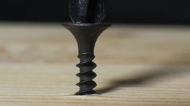 Kendi kendini beceren bir zencinin tahtaya vidalanmasının yakın çekimi. Adamın biri tahtaya vida sokuyor. Marangoz çalışıyor..