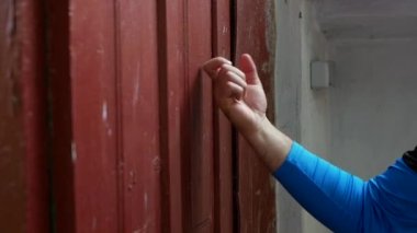 Genç bir adamın eli eski bir köyün kapısını çalar, ziyaretçi bordo bir ahşap kapıyı çalar. Yavaş çekim eski bir eve vuruyor.