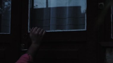 Yumuşak bir odak, karanlıkta yaşlı bir köyün kapısını çalan genç bir adam, bordo bir ahşap kapıyı çalan bir ziyaretçi. Eski bir Horor House 'da yavaş çekim vuruyor.