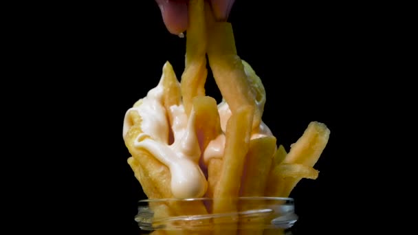 一个男人吃带有蛋黄酱的炸土豆片 吃薯条 吃黑色背景的快餐 — 图库视频影像