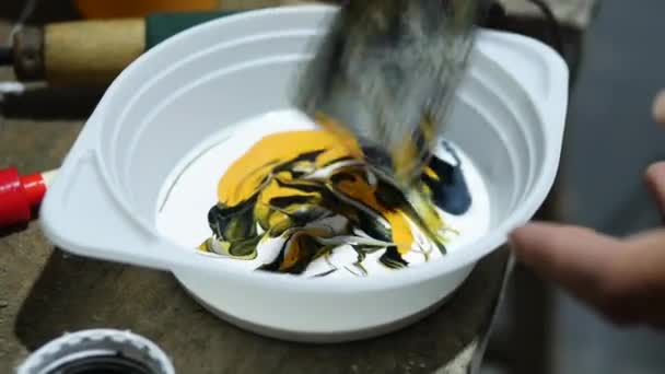 特写混合丙烯酸涂料与水枪在碗里 画在内部 画家把黑色和黄色混合起来在墙上作画 — 图库视频影像