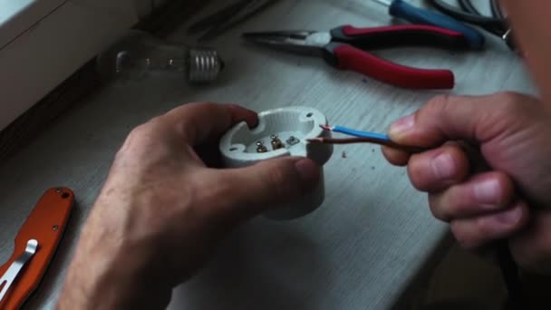 マスター電気技師は 電気ランプのソケットにワイヤを接続します — ストック動画