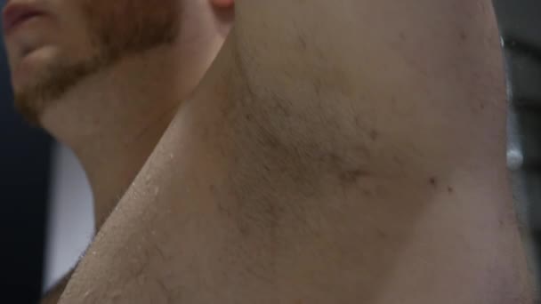 男人用刀片刮掉他的毛茸茸的腋窝 把他的头发剪掉 把他的头发从腋窝上移开 — 图库视频影像