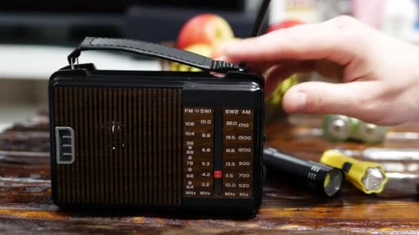 一个人把收音机里的无线电波调到一张旧木桌上 带有天线的古董接收机 按比例调模拟收音机 一个人在旧收音机里听新闻 听音乐 — 图库视频影像