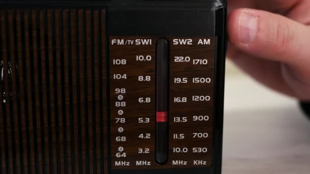 在旧的木制桌子上的收音机里放一个无线电波 扭曲旧的接收器 怀旧的生活方式按比例调模拟收音机 一个人在旧收音机里听新闻 — 图库视频影像