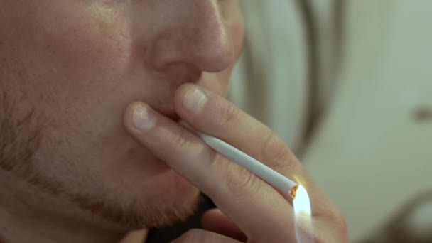 タバコの煙を吸いながら柔らかい焦点の男はタバコを点灯します — ストック動画