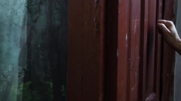 若い男の手は古い村のドアをノックし 訪問者はバーガンディの木製のドアをノック — ストック動画