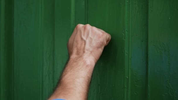 年轻人敲旧绿色的门 来访者敲木门 在外面的一座老房子里 慢动作的撞击声 — 图库视频影像