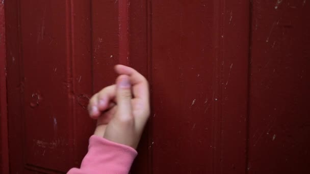 Mão Jovem Com Uma Manga Rosa Bate Uma Porta Vermelha — Vídeo de Stock