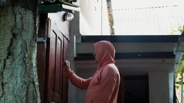 Ein Mann Kapuzenpullover Klopft Eine Alte Tür Eines Alten Hauses — Stockvideo