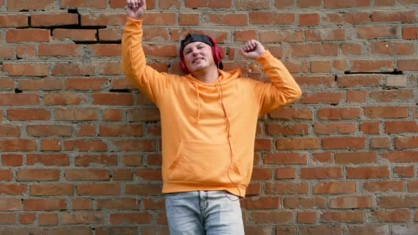 Ung Man Luvtröja Med Hörlurar Som Lyssnar Musik Medan Han — Stockvideo