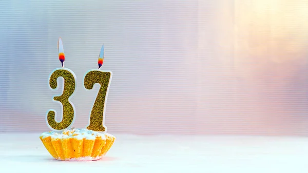 Happy birthday card from candles with the number 37, golden numbers from candles for congratulations on any holiday