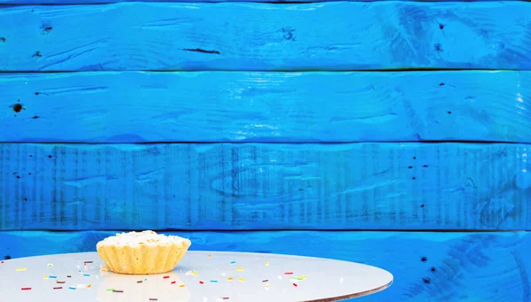Festive background with a cake on the background of blue boards, a beautiful background for a birthday cop space