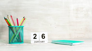 January 26 calendar. The concept of the date of the season. Pencils in a basket against the background of a notebook and the date of the month. Copy space calendar cube. clipart