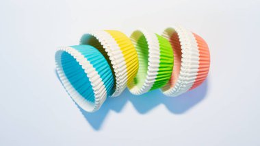 Beyaz arka planda çok renkli kek ve kek kutuları, yakın planda renkli kağıt kek kutuları.