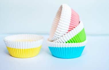 Beyaz arka planda çok renkli kek ve kek kutuları, yakın planda renkli kağıt kek kutuları.