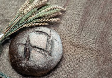  Eski mavi tahtaların arka planında iştah açıcı taze ekmek, buğday dikenleri. Ev yapımı ekmek.