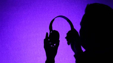 Kulaklıklı bir adamın portresi, müzik geçmişi, kulaklıklı mutlu sarı renkli neon adam müzik dinliyor ve kulüp gözlüğü takıyor. Boşluğu kopyala