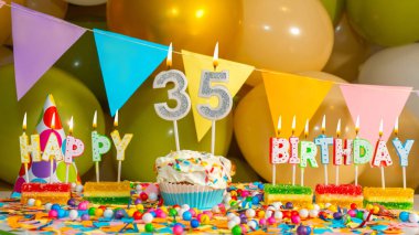 Otuz beş yıllık mumlu kremalı kek, 35 yıllık doğum günü kartı, mumlu doğum günü pastası ve doğum günü süslemeleri..
