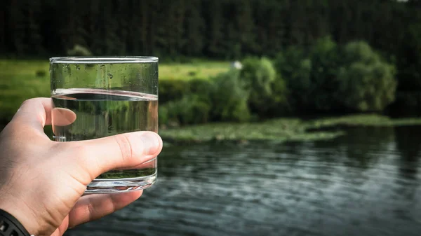 A glass of drinking water on a mountain slope, mineral water with bubbles on the background of nature