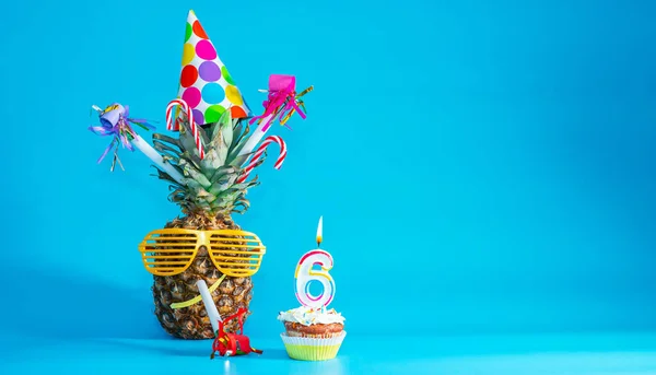 Creative congratulations on six years for a child. Pineapple with glasses in festive decorations. copy space. 6 year old birthday